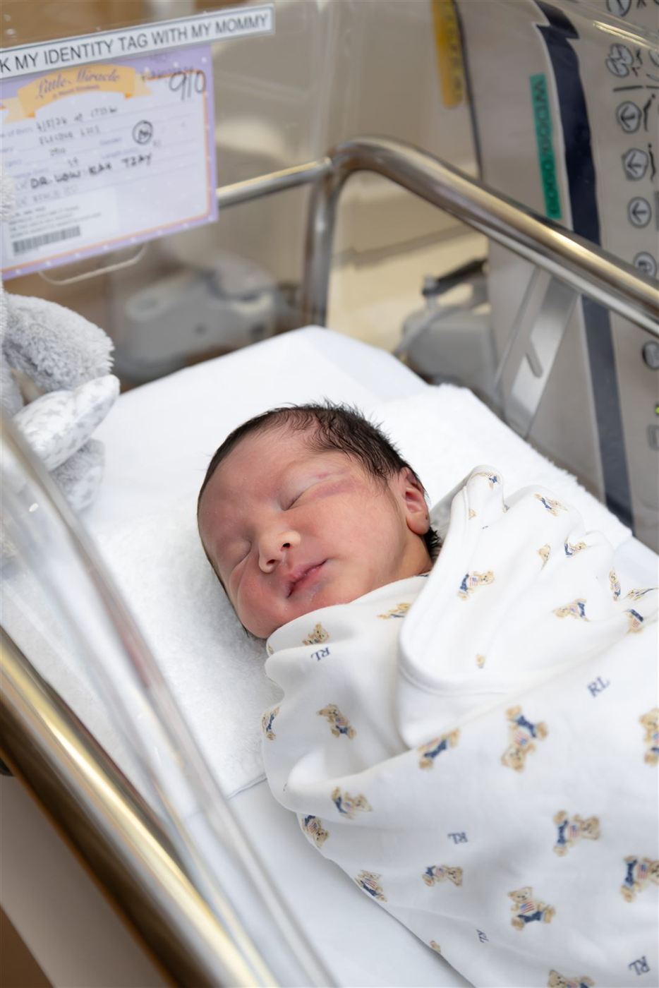 Newborn sleeping in a hospital bassinet