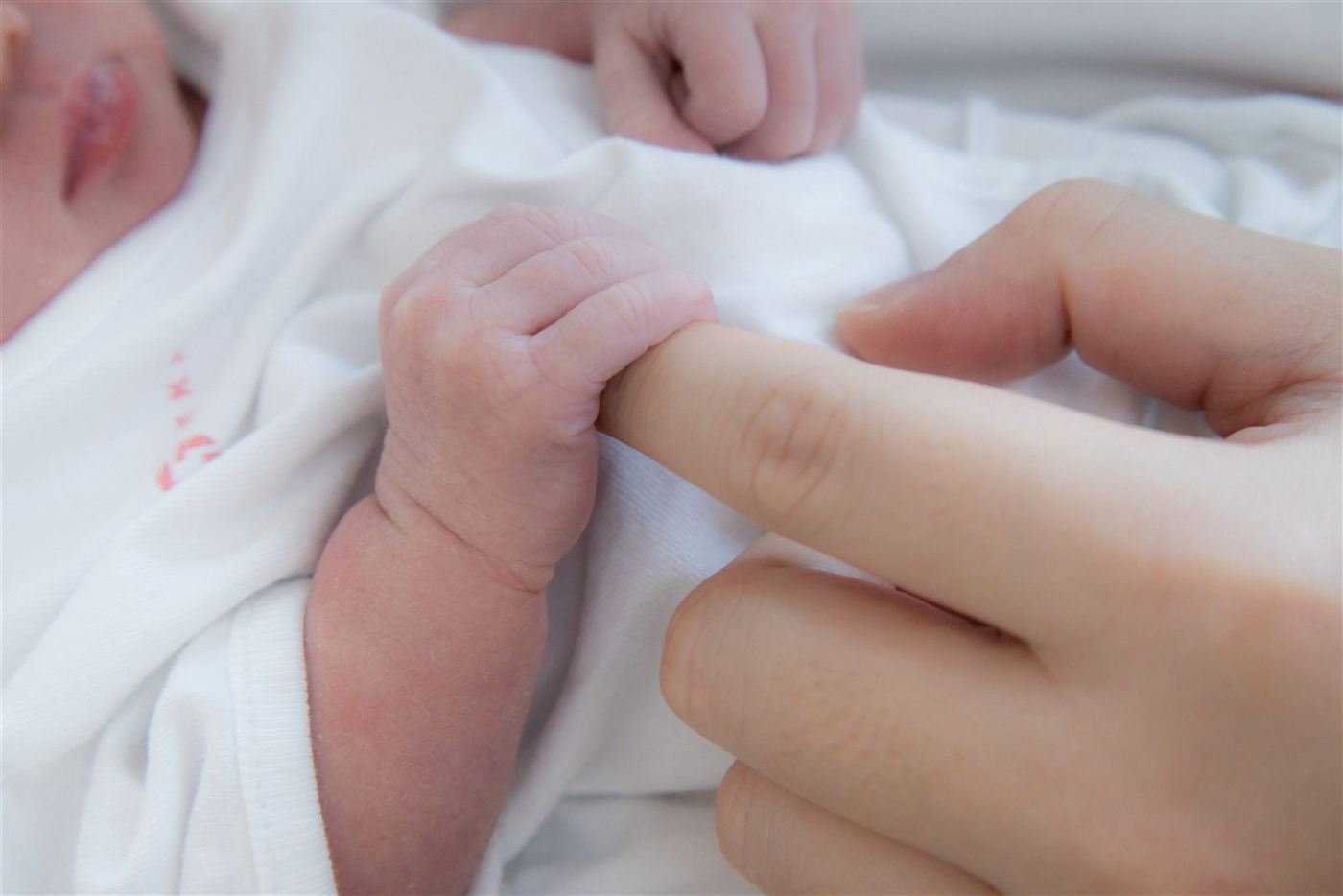 Newborn gripping a parent's finger in the first days
